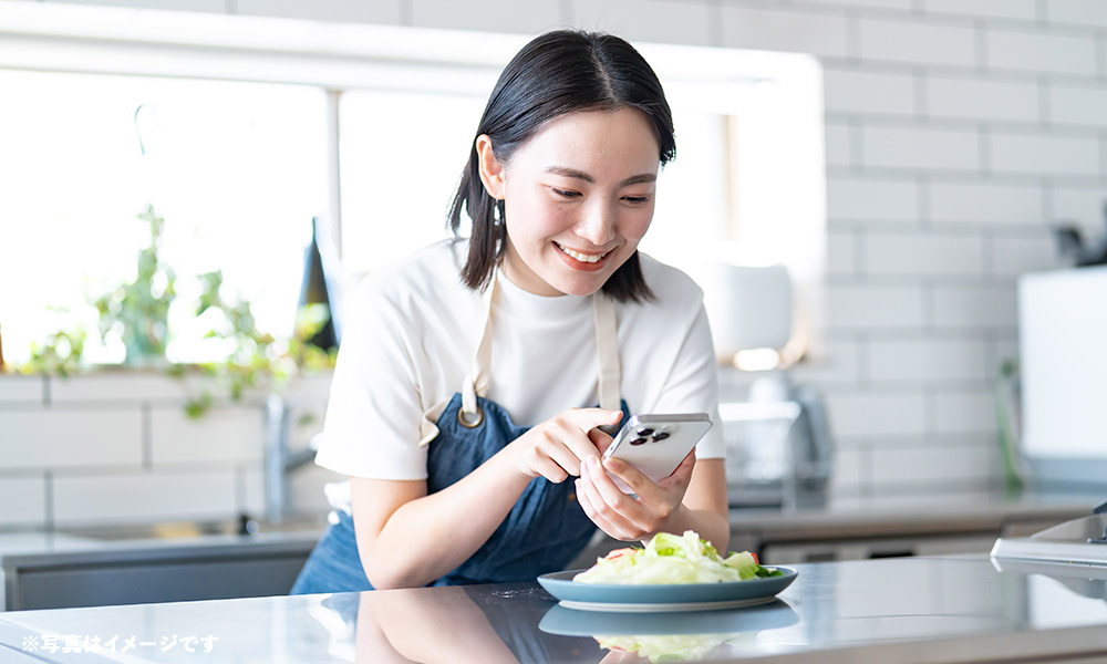 笑顔でスマホを操作する女性